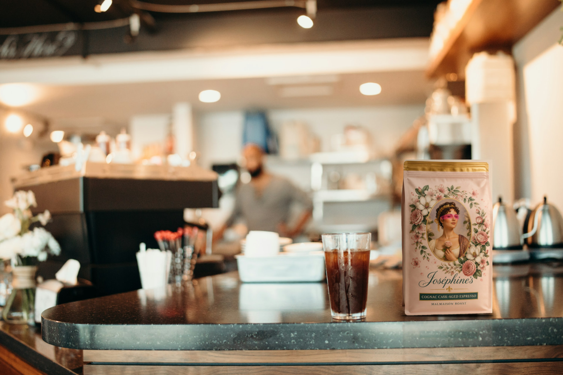 An iced coffee on the café counter beside a Joséphine’s bag