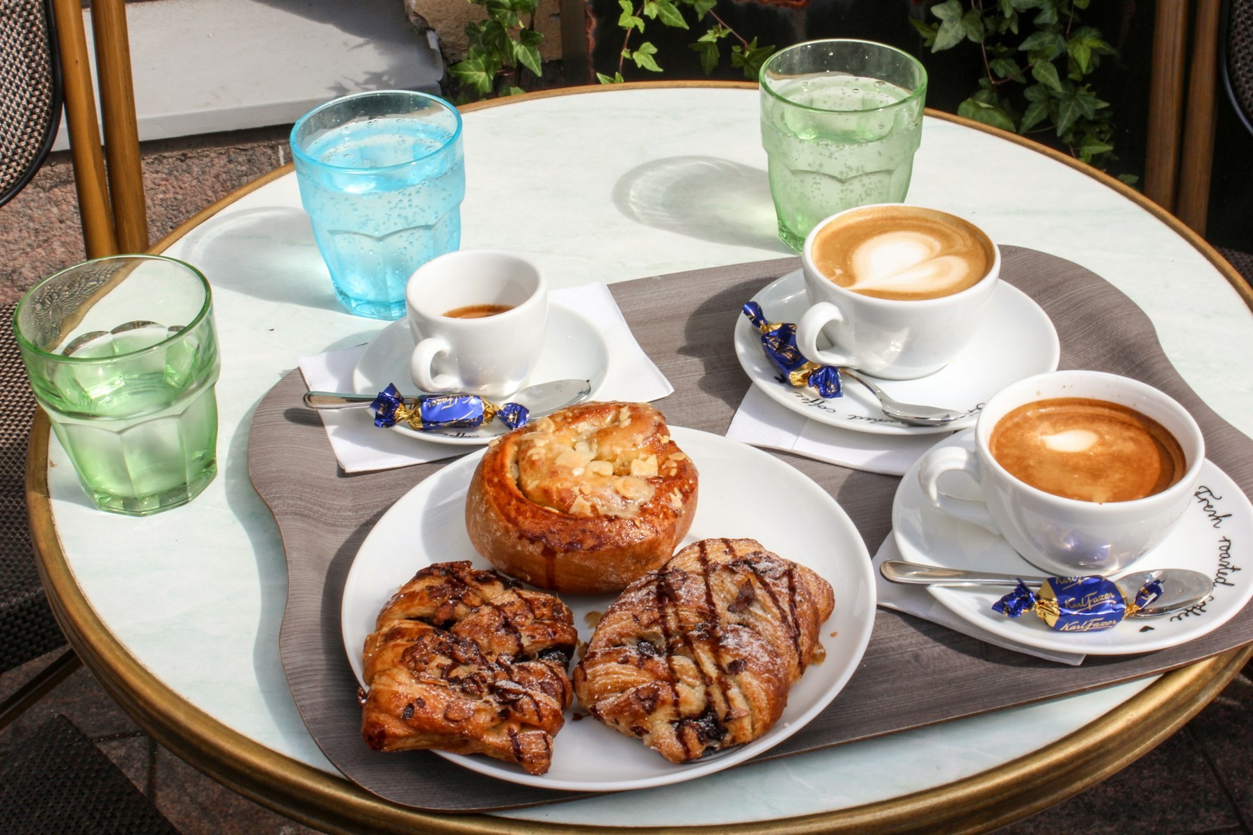 Cappuccinos and pastries on a marble café table