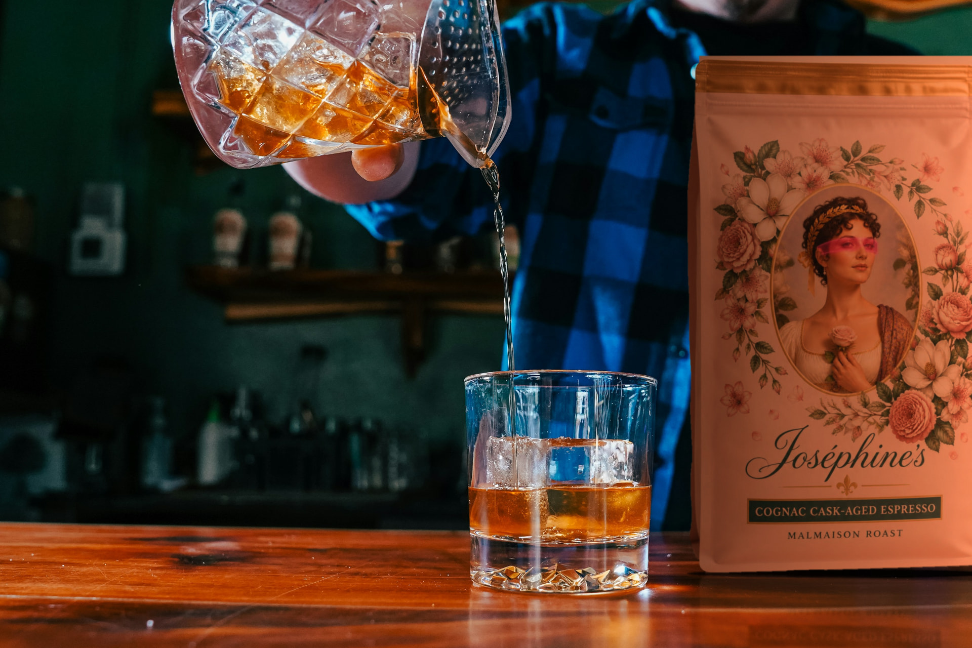 Cognac cask-aged espresso poured over a large ice cube at the bar, a Joséphine’s Malmaison Roast bag resting beside the glass